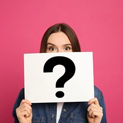 Woman holding a card with a question mark on it over her face