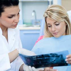 dentist and patient examining x-ray